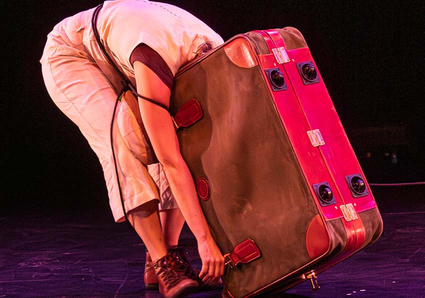 A person with his head inside a suitcase